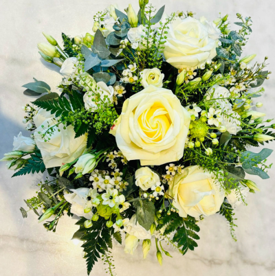 Pure Elegance - This bouquet showcases the timeless beauty of white roses and lush greenery. The simplicity and grace of this arrangement make it perfect for any formal event or as a heartfelt gift for a loved one. It also suits solemn occasions like funerals.