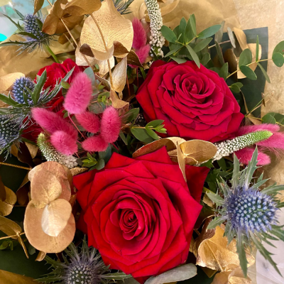 Golden Romance - A luxurious bouquet featuring deep red roses, golden accents, and a touch of blue thistle for contrast. This arrangement exudes elegance and romance, making it an excellent choice for anniversaries or special celebrations.