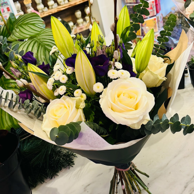 Classic Whites - This elegant bouquet combines white roses with delicate fillers and lush greenery, perfect for any occasion where you want to express pure and heartfelt sentiments.