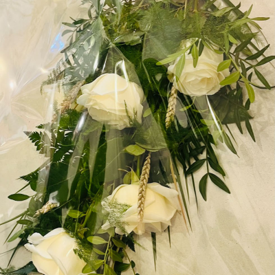 White Rose Cascade - A graceful cascade of white roses and greenery, beautifully arranged to create a sophisticated and timeless look. This arrangement is ideal for weddings, anniversaries, or as a stunning display in any setting. Also fitting for funeral tributes.